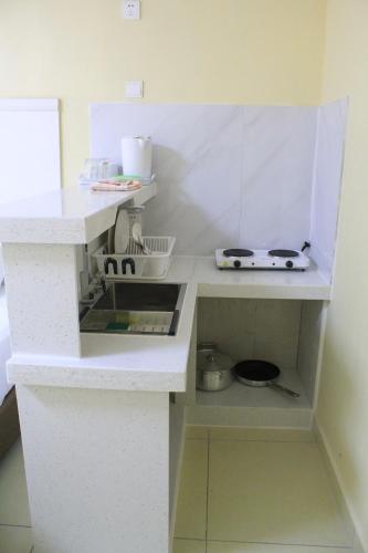 uma cozinha com um balcão branco e um lavatório em Central Bay Motel em Port Vila