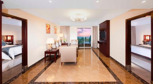 a hotel room with a desk and a bedroom at Wyndham Garden Wenchang Nanguo in Wenchang