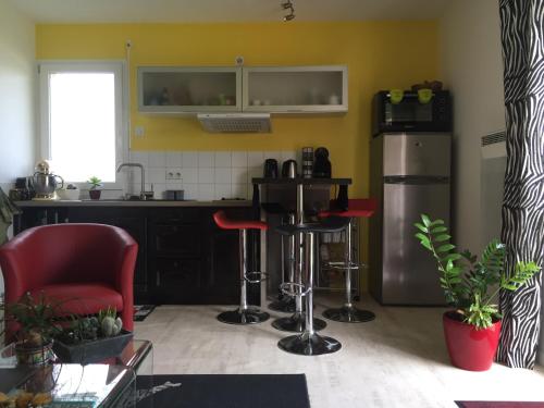 uma cozinha com um balcão, bancos e um frigorífico em Maison à la Campagne à 2km du Circuit de Bresse em Sagy