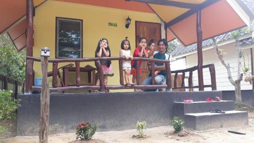 a group of people standing on the porch of a house at Long Beach Garden Resort in Ko Lanta
