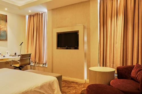 a hotel room with a bed and a desk at Park Plaza Faridabad in Faridabad