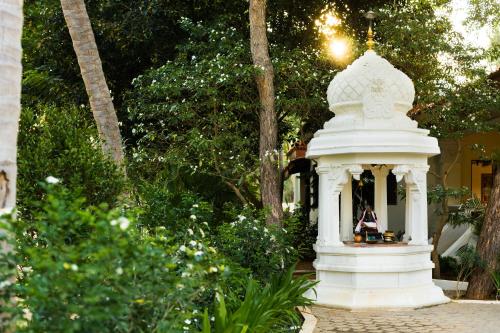 a white gazebo in the middle of a garden at Mantra Koodam Kumbakonam - A CGH Earth Experience in Kumbakonam