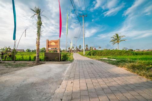 a brick road with palm trees and a building at Uma Kakul Villas in Tegalalang