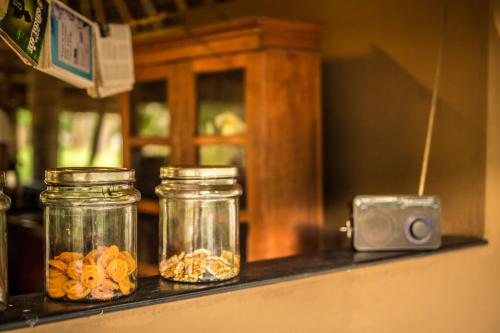 two jars of food on a shelf with a camera at Mantra Koodam Kumbakonam - A CGH Earth Experience in Kumbakonam