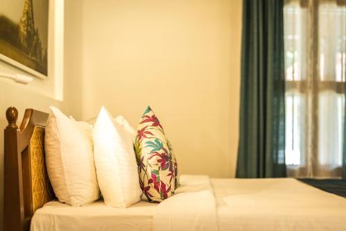 a bedroom with a bed with white pillows at Mantra Koodam Kumbakonam - A CGH Earth Experience in Kumbakonam