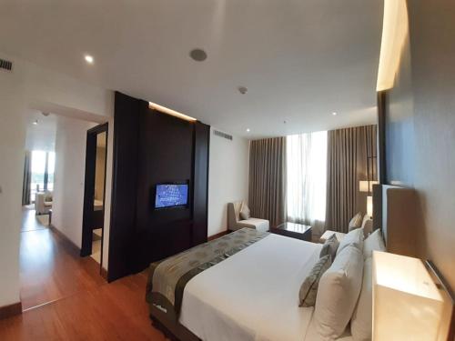 a hotel room with a large bed and a television at Vivanta Colombo, Airport Garden in Negombo