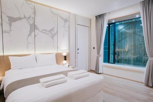 a bedroom with a large white bed and a window at Artino Hotel - SHA Extra Plus in Bangkok