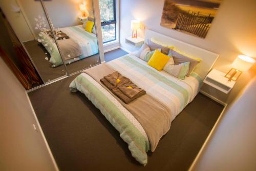 a large bed in a bedroom with a mirror at Coorong Cabins in Meningie
