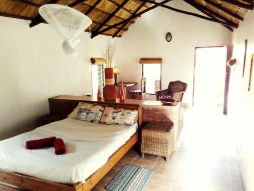 um quarto com uma cama, uma secretária e uma cadeira em Barefoot Lodge and Safaris - Malawi em Lilongwe