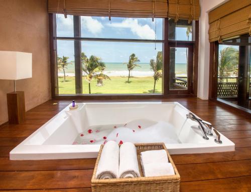 a bath tub in a room with a view of the ocean at Anantaya Resort & Spa Chilaw in Chilaw