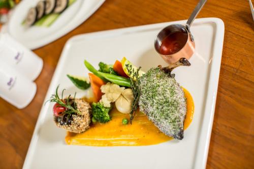 a white plate with a dish of food on a table at Anantaya Resort & Spa Chilaw in Chilaw