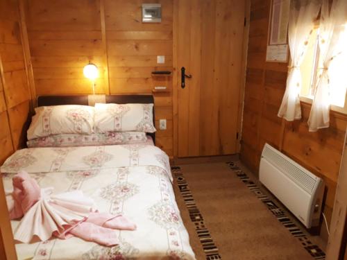 a bedroom with a bed with a dress on it at Etno selo EDEN in Žeravački Potok