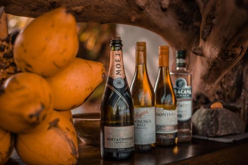 three bottles of wine sitting on a table with oranges at Anantaya Resort & Spa Chilaw in Chilaw