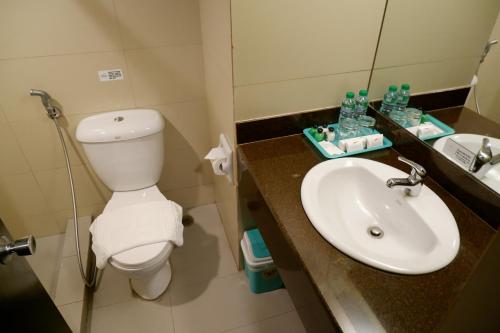 a bathroom with a toilet and a sink at Tower Inn Makati Business Hotel in Manila