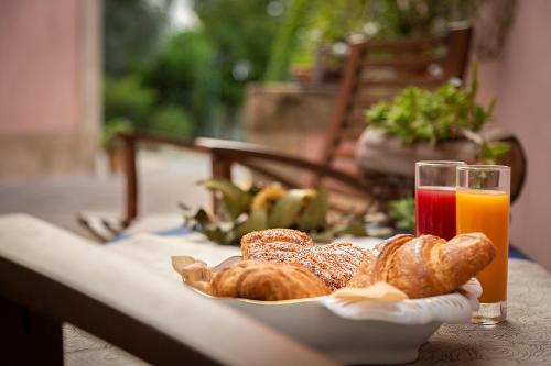 een bord gebak en een glas sinaasappelsap bij Villa Maria Affittacamere in Canicattini Bagni