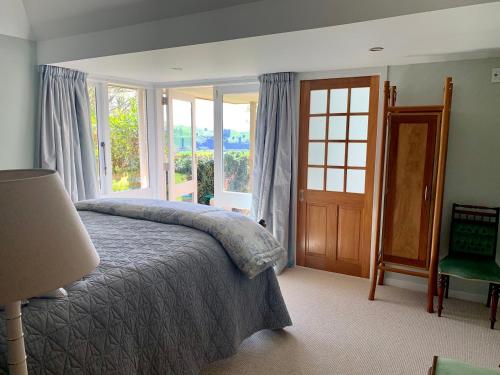 a bedroom with a bed and a large window at Omaka Lodge in Taumarunui