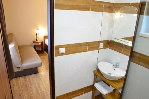 a bathroom with a sink and a mirror at Penzion Tramín in Valtice