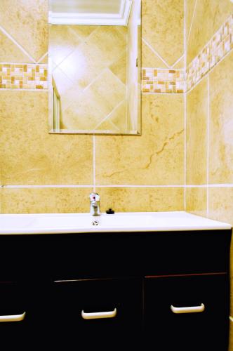 a bathroom with a sink and a mirror at Rip van Winkel Guest House in Lephalale