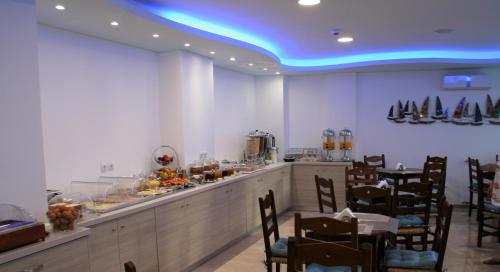 a restaurant with a bar with wooden chairs and a blue ceiling at Naiades Marina Hotel in Agios Nikolaos