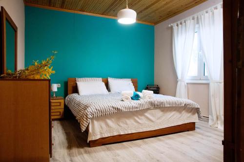 a bedroom with a bed with a blue wall at SWEET HOME, LOUTRA POZAR in Dorothéa