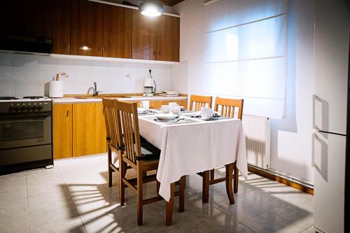 a kitchen with a table with a white table cloth on it at SWEET HOME, LOUTRA POZAR in Dorothéa