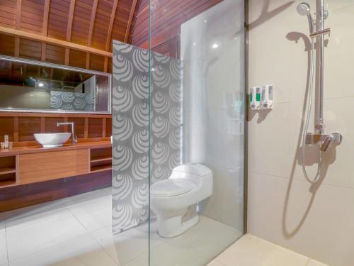 a bathroom with a shower with a toilet and a sink at Sekar Arum Riverside Resort in Canggu in Tanah Lot