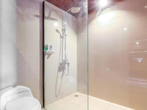 a bathroom with a glass shower with a toilet at Sekar Arum Riverside Resort in Canggu in Tanah Lot