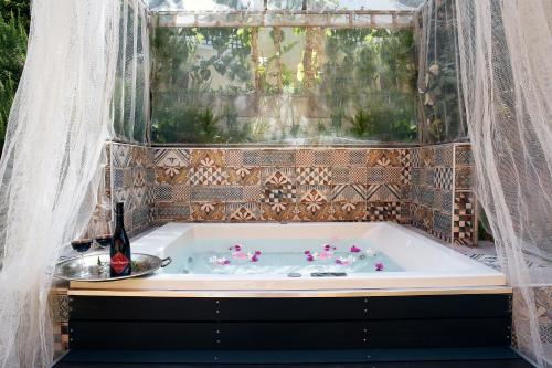 a bath tub with a bottle of wine in it at Orpheas Resort Hotel (Adults Only) in Georgioupolis