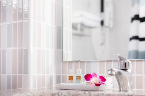 班納的住宿－KC廣場詩娜卡琳酒店，浴室水槽上装有粉红色的花