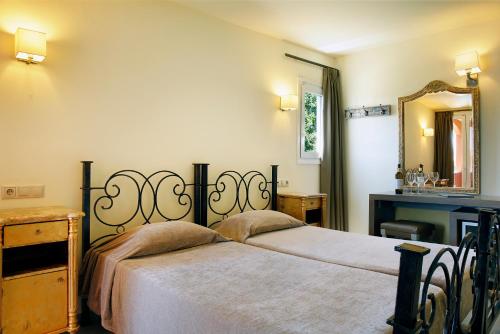 a bedroom with a bed and a mirror at Orpheas Resort Hotel (Adults Only) in Georgioupolis