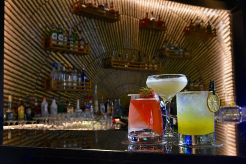 two cocktails sitting on top of a bar at Mövenpick Hotel Bahrain in Manama