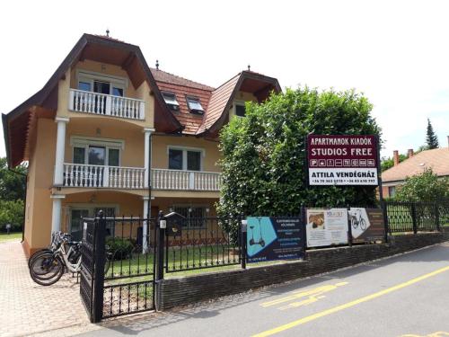 a house with a sign in front of a fence at Attila Vend&eacute;gh&aacute;z in H&eacute;v&iacute;z