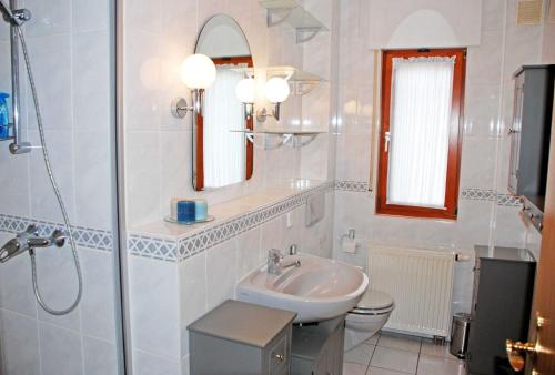 ラウターバッハにあるGaestehaus Kapitaen Winstonのバスルーム(洗面台、トイレ、鏡付)