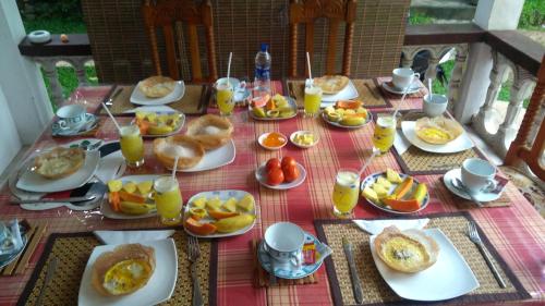a table topped with plates of food and drinks at Senasuma Homestay in Ella