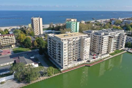 Oasis by the Lake - Solid Residence Mamaia Apartment في مامايا: اطلالة جوية على مبنى بجانب تجمع المياه