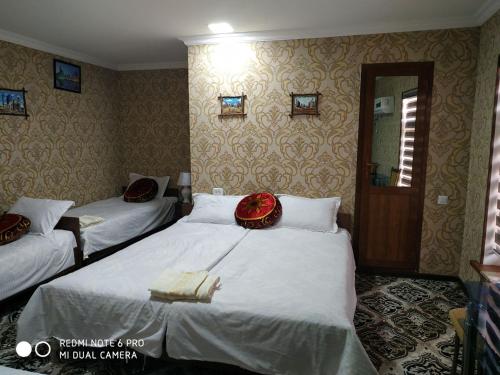a hotel room with two beds in a bedroom at Imran&Bek in Samarkand