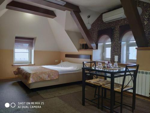 1 dormitorio con 1 cama y 1 mesa con 1 cama individual en Domino Hotel, en Nizhny Novgorod