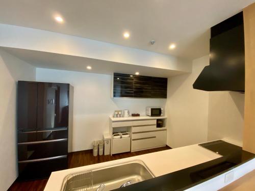 a kitchen with a sink and a counter top at M´s Stay Okinawa in Chatan