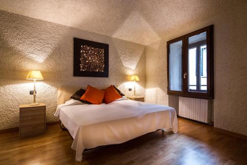a bedroom with a bed with orange pillows and a window at Cernobbio Art Apartment in Cernobbio