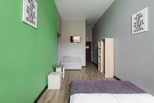 a bedroom with a bed and a green wall at Nomera na Sadovoy in Saint Petersburg