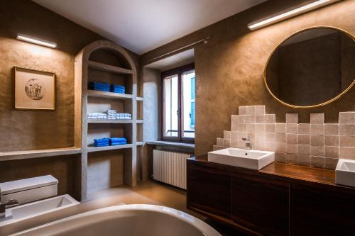 a bathroom with a tub and a sink and a mirror at Cernobbio Art Apartment in Cernobbio
