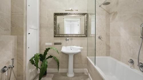 W łazience znajduje się umywalka, wanna i lustro. w obiekcie Lion Apartments - Scandi Love BestSeller with 3 bedrooms w mieście Sopot