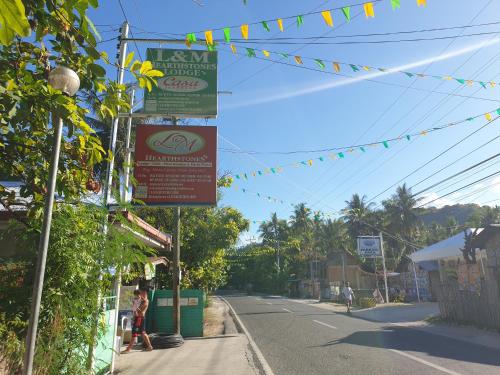 a street with signs on the side of a road at L & M Hearthstones Lodge in Oslob