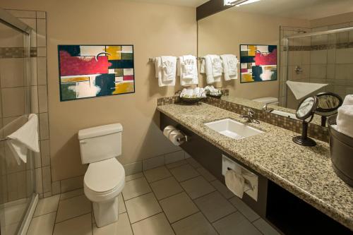a bathroom with a toilet and a sink and a mirror at Pahrump Nugget Hotel & Casino in Pahrump