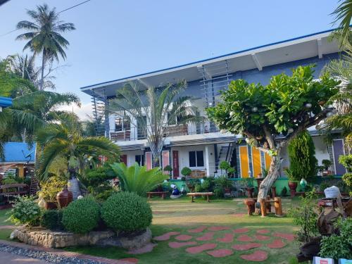 a building with a garden in front of it at L & M Hearthstones Lodge in Oslob