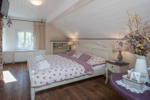 Un dormitorio con una gran cama blanca y una mesa en Samoobslužný Penzion Stříbrný vítr en Horní Planá