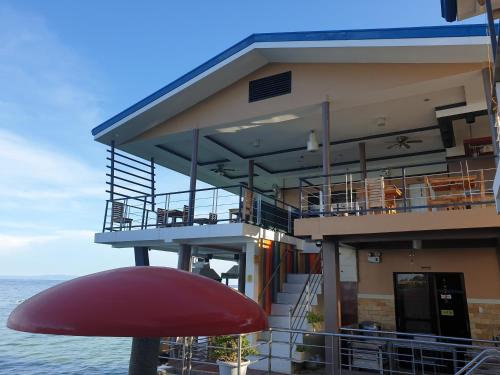 a building with a red mushroom in front of it at L & M Hearthstones Lodge in Oslob