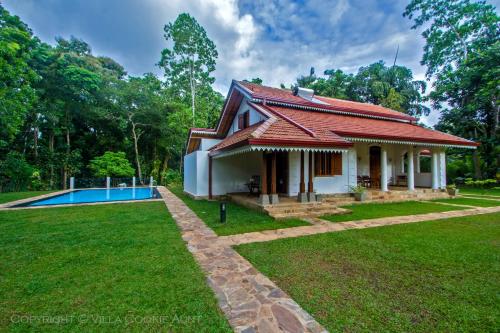 a house with a red roof and a swimming pool at Villa Cookie Aunt in Bentota