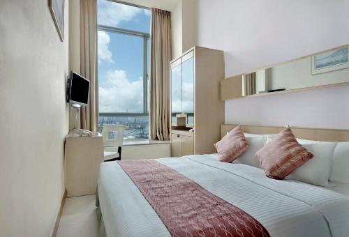 a bedroom with a large bed with a large window at Rambler Garden Hotel in Hong Kong