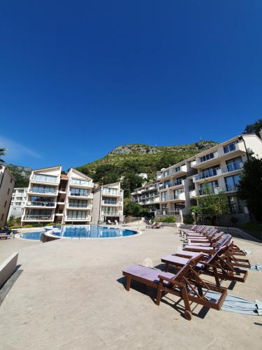 a group of chaise lounges on the beach in a resort at Charming apartment near beach in Sveti Stefan